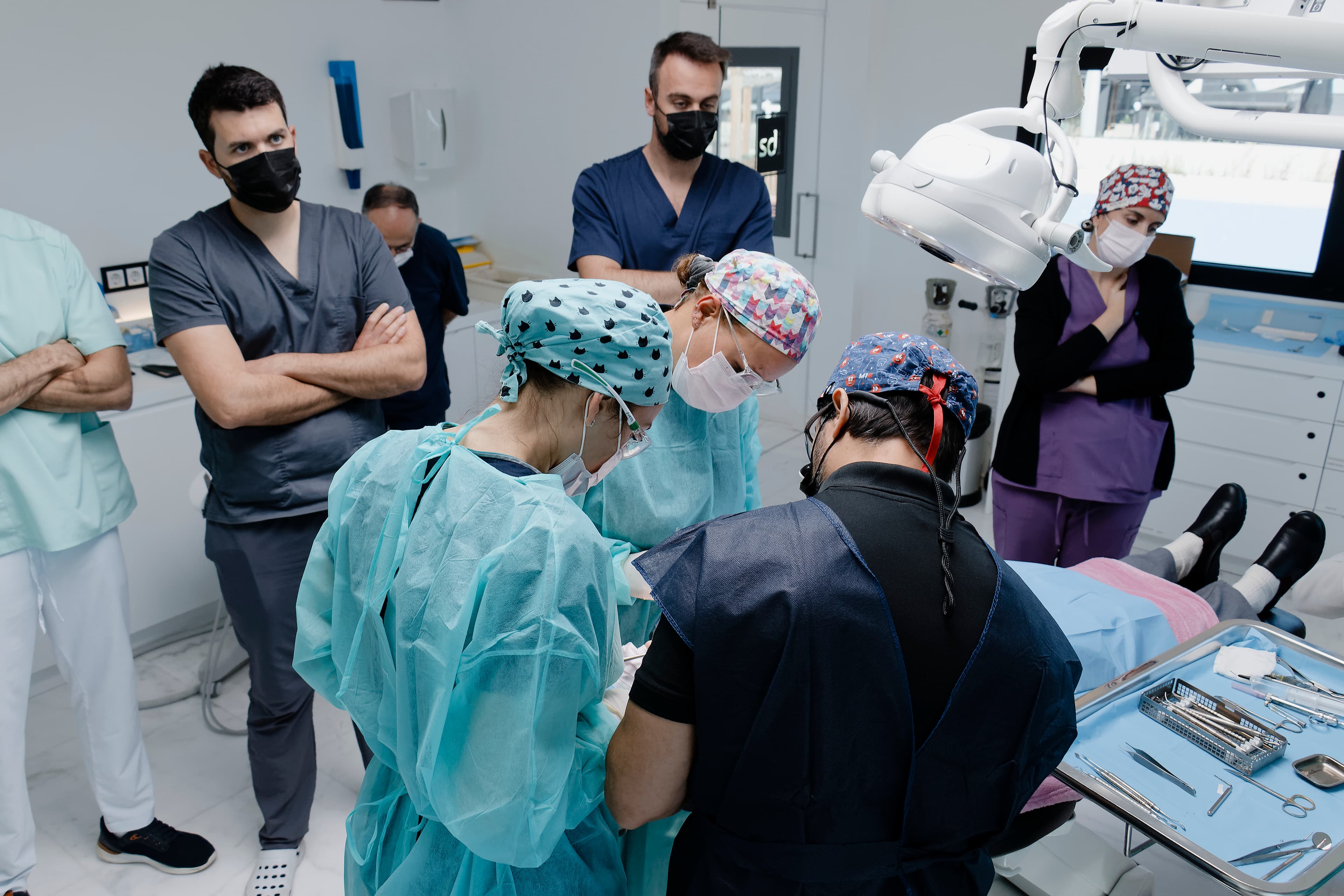 Sesión de cirugía en directo del Curso de Implantología y Regeneración De 0 a 100 de Salgado Academy — alumnos observando procedimiento con paciente real en el quirófano de SDI Orihuela Costa
