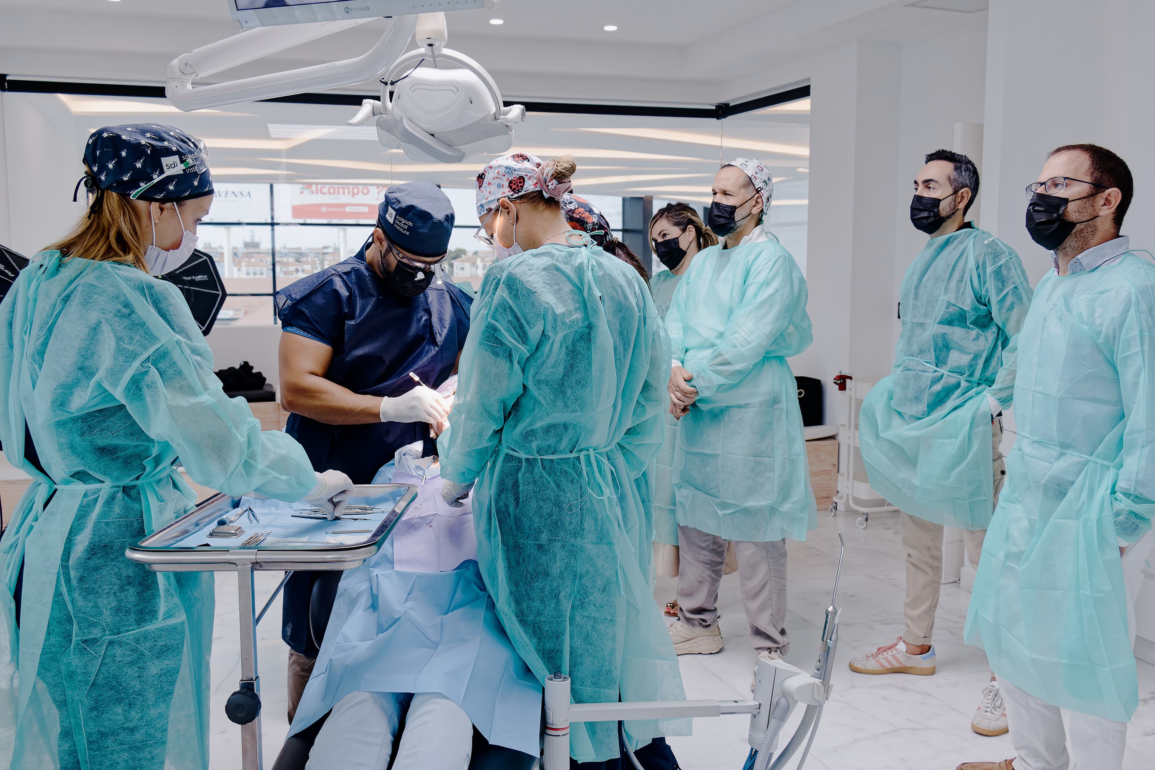 El Dr. Alberto Salgado operando en directo durante los Cursos Intensivos AlphaBio Tec × Salgado Academy en el quirófano de SDI Orihuela Costa, con grupo reducido de odontólogos observando
